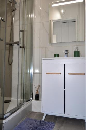 a bathroom with a white vanity and a shower at Daz house in Sevran