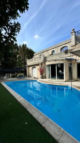 une grande piscine bleue devant une maison dans l'établissement Villa piscine confort, barbecue, à Marseille