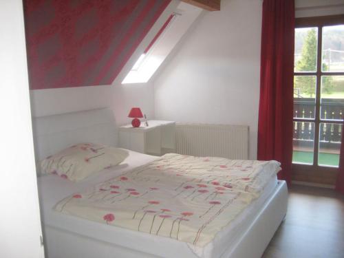 a bedroom with a white bed and a window at Pension Wolkenreich in Oberhaag