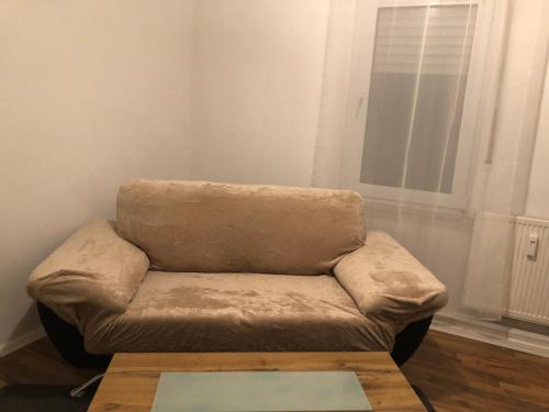 a brown couch in a room with a coffee table at Ferienwohnung 2Doppel 1 Einzel Bett in Siegen