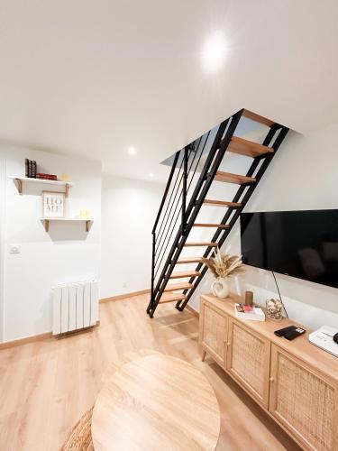 a living room with a staircase and a tv at Maison Cosy Centre Gare Amiens in Amiens