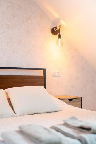 a bedroom with a bed and a light on the wall at Maison Cosy Centre Gare Amiens in Amiens