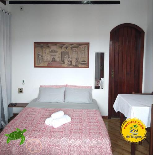 a bedroom with a bed with two towels on it at Pousada Casa de Buzios in Búzios