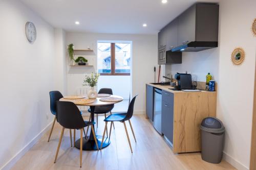 une cuisine et une salle à manger avec une table et des chaises dans l'établissement Destination Royale, à Annecy