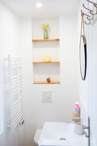 a white bathroom with a sink and shelves at Maison Cosy Centre Gare Amiens in Amiens