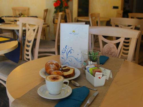 a table with a cup of coffee and pastries on it at Blu Tropical Resort in Zambrone