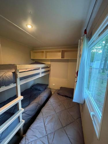 Cette petite chambre comprend des lits superposés et une fenêtre. dans l'établissement Escale Cœur De Vendée, à La Boissière-de-Montaigu