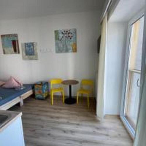 a room with a table and two yellow chairs at MINATO Apartments Ostrava center in Ostrava