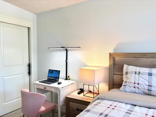 a bedroom with a bed and a desk with a laptop at NEW cozy beautiful house with pool and hot tub in Fair Oaks