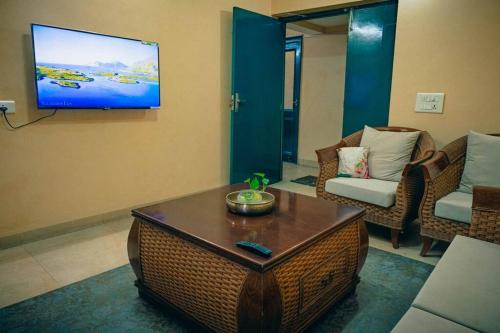 a living room with a couch and a tv on the wall at Cozy 3 BHK in the Heart of Ludhiana in Baddowāl