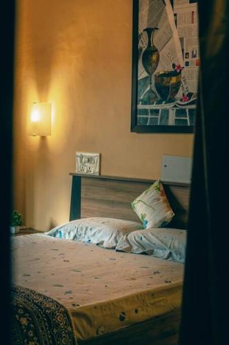 a bedroom with a bed and a picture on the wall at Cozy 3 BHK in the Heart of Ludhiana in Baddowāl