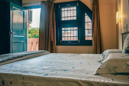 a large bed in a bedroom with a window at Cozy 3 BHK in the Heart of Ludhiana in Baddowāl