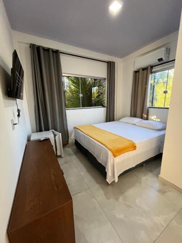 a bedroom with a bed and a large window at Suítes Preguiça in Sao Jorge