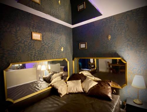 - un grand lit dans une chambre dotée d'un mur bleu dans l'établissement Love Room Plaisir Secret, à Limoges