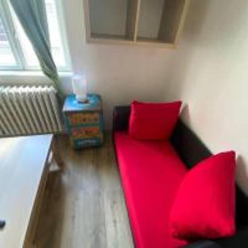 a red couch with red pillows in a room at MINATO Apartments Ostrava center in Ostrava