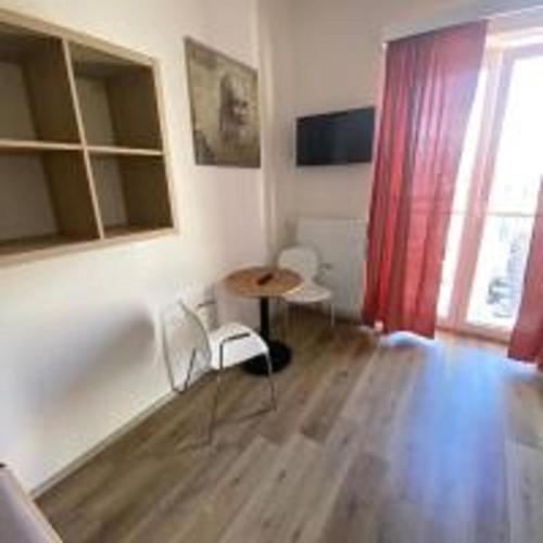 a living room with a table and a red curtain at MINATO Apartments Ostrava center in Ostrava