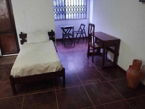 a bedroom with a bed and a table and chairs at Suítes no centro in Belém