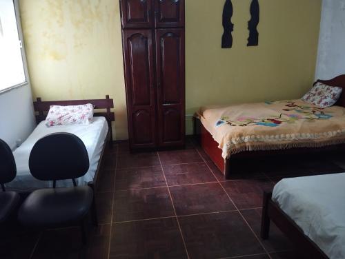 a room with two beds and a chair in it at Suítes no centro in Belém