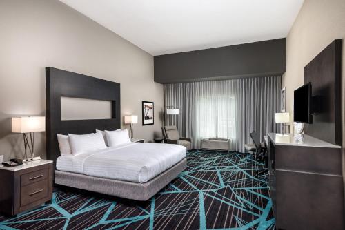 a hotel room with a bed and a flat screen tv at Holiday Inn Express & Suites - Charlotte Airport by IHG in Charlotte