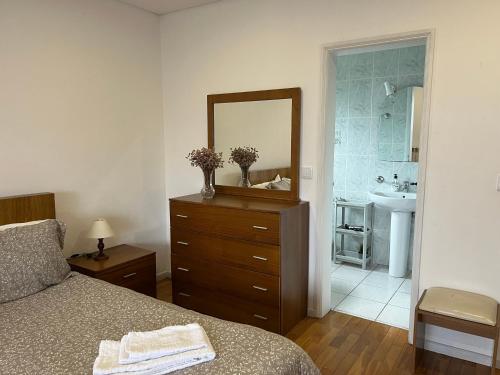 a bedroom with a dresser with a mirror and a sink at Casa de Casarelhos - Vistas rio - "Gerês" in Geres