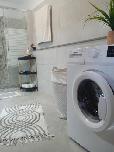 a washing machine in a bathroom with a rug at Popi's house in town in Kalymnos