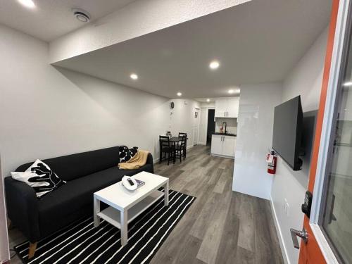 a living room with a black couch and a table at The Urban Nest in Calgary