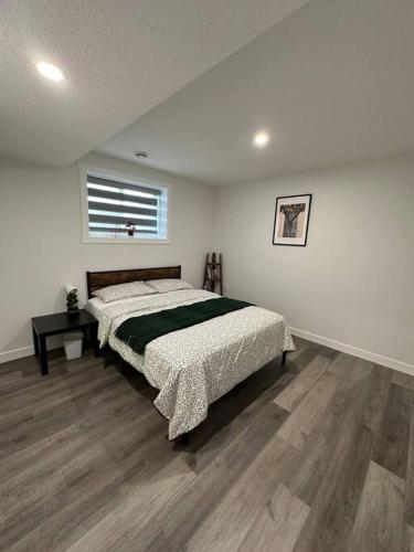 a bedroom with a bed with a green blanket on it at The Urban Nest in Calgary