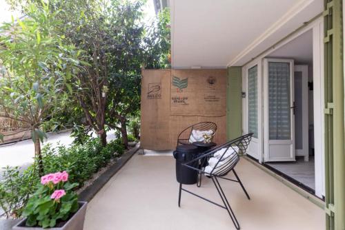 a cat sitting on a chair on a porch at Ecrin de verdure aux portes de Paris in Arcueil