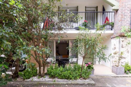 a house with a balcony and trees and plants at Ecrin de verdure aux portes de Paris in Arcueil