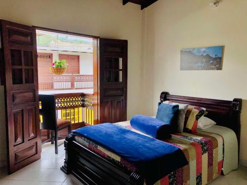 a bedroom with a bed and a window with a piano at HOTEL PLENITUD JARDÍN - Transporte, Tours y Más in Jardin