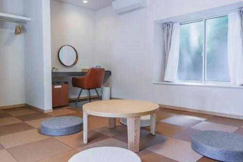a room with a table and a chair and a window at Guesthouse TOMARITOMARO in Shikineshima
