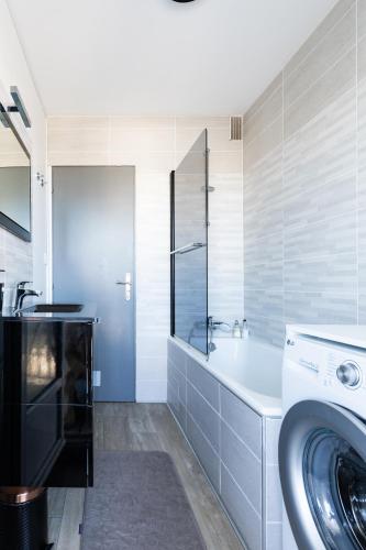 une salle de bain avec un lavabo et une machine à laver dans l'établissement Appartement d'exception avec vue plongeante sur l'Océan - Elégance et évasion, à Les Sables-dʼOlonne