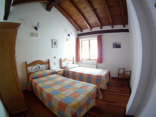 1 dormitorio con 2 camas y ventana en Viviendas Rurales El Cantón, en Cucayo