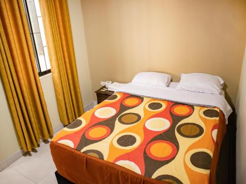 a bedroom with a bed with a colorful blanket at Resort Maldo in Ayacucho