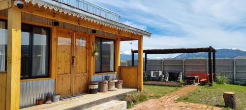Casa de madera con ventanas grandes y patio en Tiny House en Trevelin "El Ranchito", en Trevelín