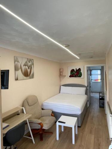a bedroom with a bed and a desk and a chair at Welcoming Guesthouse in Cambridge