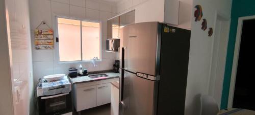 a small kitchen with a refrigerator and a window at Cantinho do descanso in Bertioga