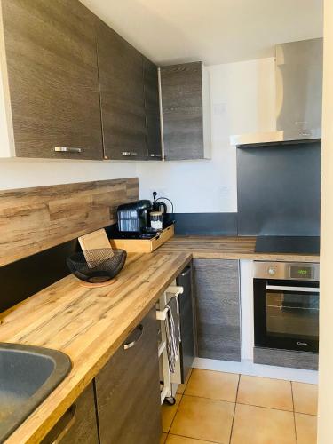 - une cuisine avec un comptoir en bois et des placards en bois dans l'établissement Maison T3 avec jardin, à Narbonne