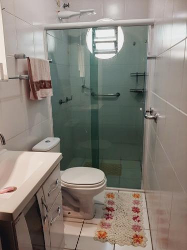 a bathroom with a toilet and a glass shower at Casa aluguel de temporada em Florianópolis in Florianópolis