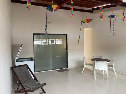 ein Raum mit Tisch und Stühlen und Drachen in der Unterkunft Casa de praia em Tamandaré - Carneiros in Tamandaré