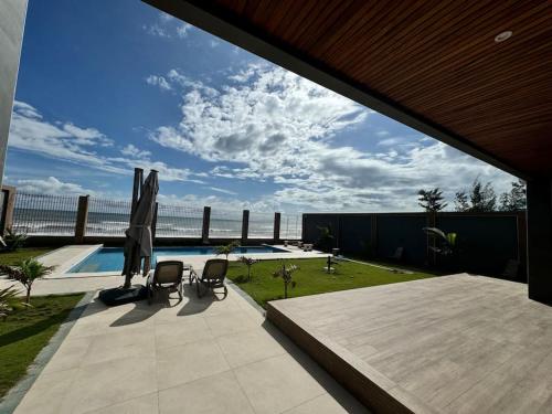 a patio with two chairs and a swimming pool at OceanView Ndayane - Villa de luxe avec vue sur mer et piscine in Ndayane