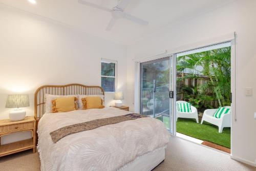 a bedroom with a bed and a sliding glass door at 4-18 Peregian Esplanade, Peregian Beach QLD 4573 in Peregian Beach
