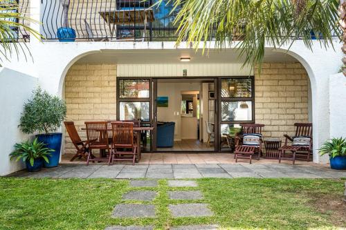 a patio with chairs and a table in a house at Onetangi Beach Apartments in Onetangi