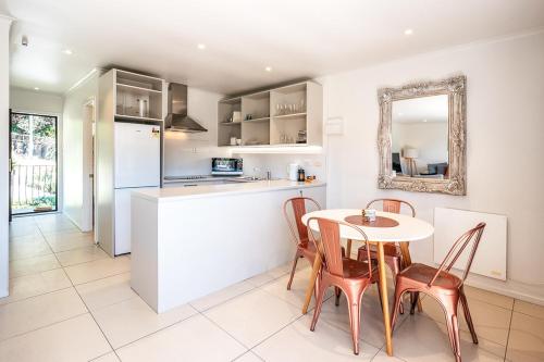 a kitchen and dining room with a table and chairs at Onetangi Beach Apartments in Onetangi