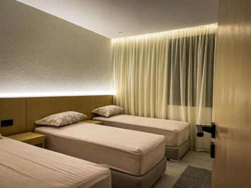 a hotel room with two beds and a window at CASA ULIVO villa en pleine nature in Dar Caïd Bou Driss