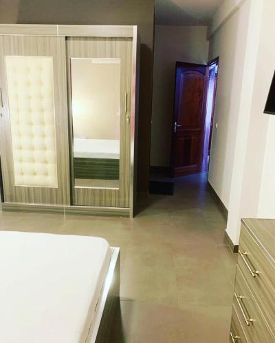 ein Zimmer mit einem Spiegel und ein Schlafzimmer mit einem Bett in der Unterkunft CosyServives in Grand Médina