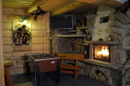 a kitchen with a stone fireplace and a stove at Willa Tatrzański Zomecek in Kościelisko
