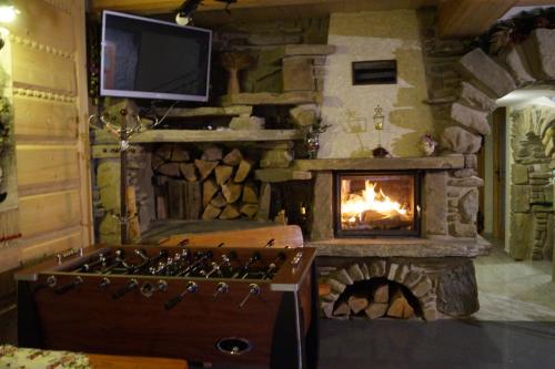 a stone fireplace in a room with a stove at Willa Tatrzański Zomecek in Kościelisko