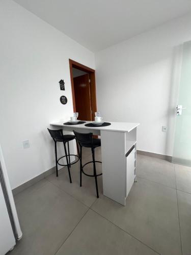 a kitchen with a counter and stools in a room at Casa Fabluys 3 in Florianópolis