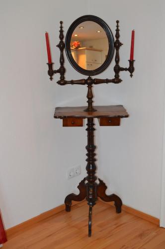 a mirror on a stand with two candles on it at Appartements Strasser Angelika in Westendorf